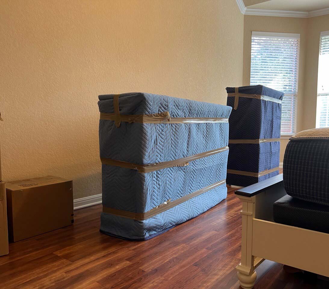 Efficient local moving services within San Antonio, with movers carefully wrapping household items with moving blankets.